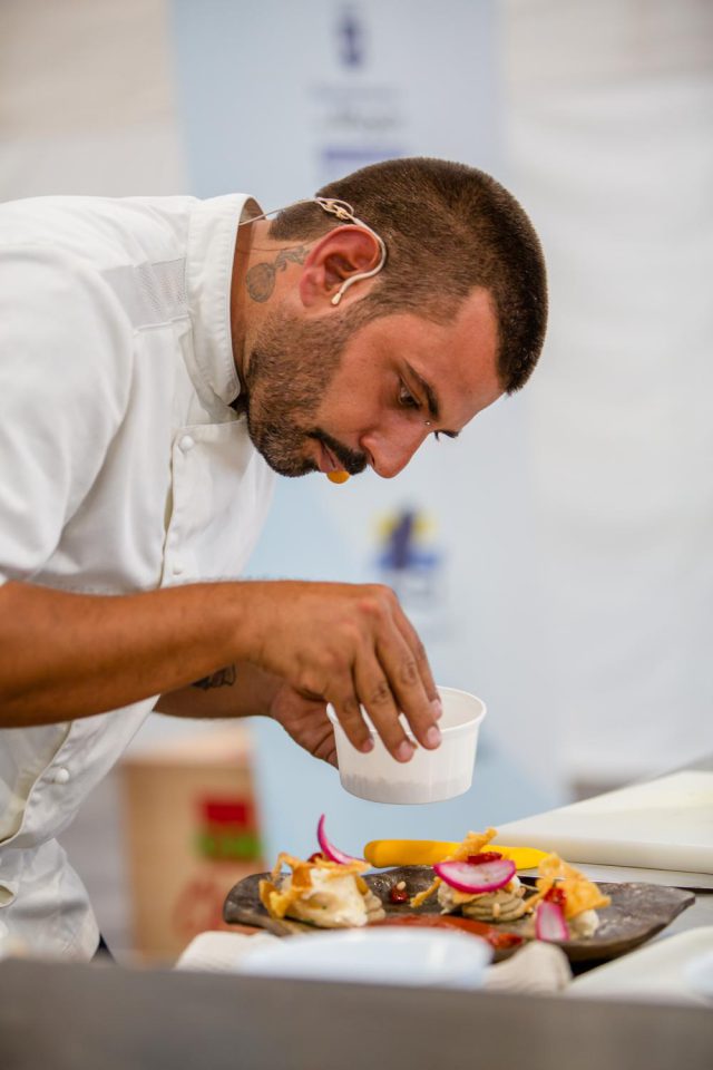 Paolo Dorazio Finalizando Su Plato De Atún En Salazón De Bergamota Mole De Tomate Chip De Polenta Y Cebolla Fermentada En Su Shoowcooking Sobre El Uso Del Atún En La Cocina Mediterránea