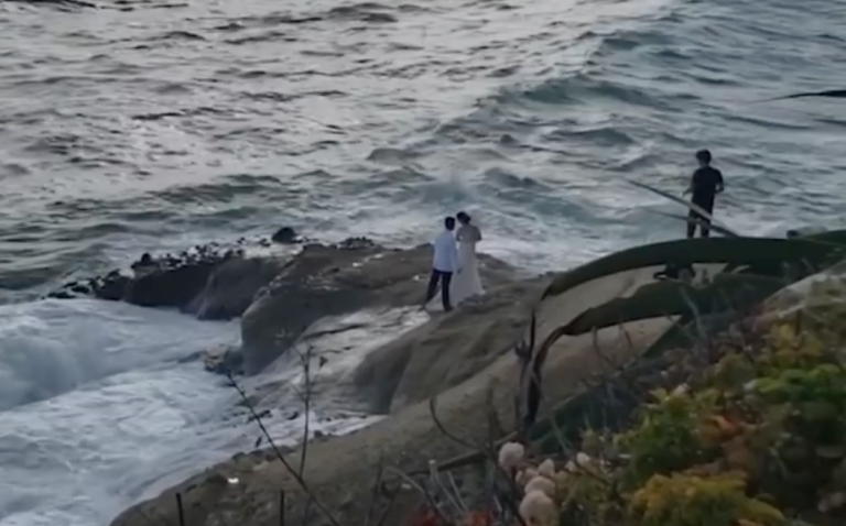 Una ola gigante arrastra mar adentro a una pareja de recién casados durante una sesión de fotos