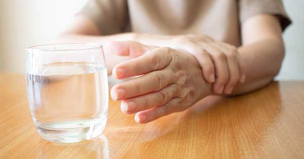 Temblores De Manos Al Coger Un Vaso De Agua.