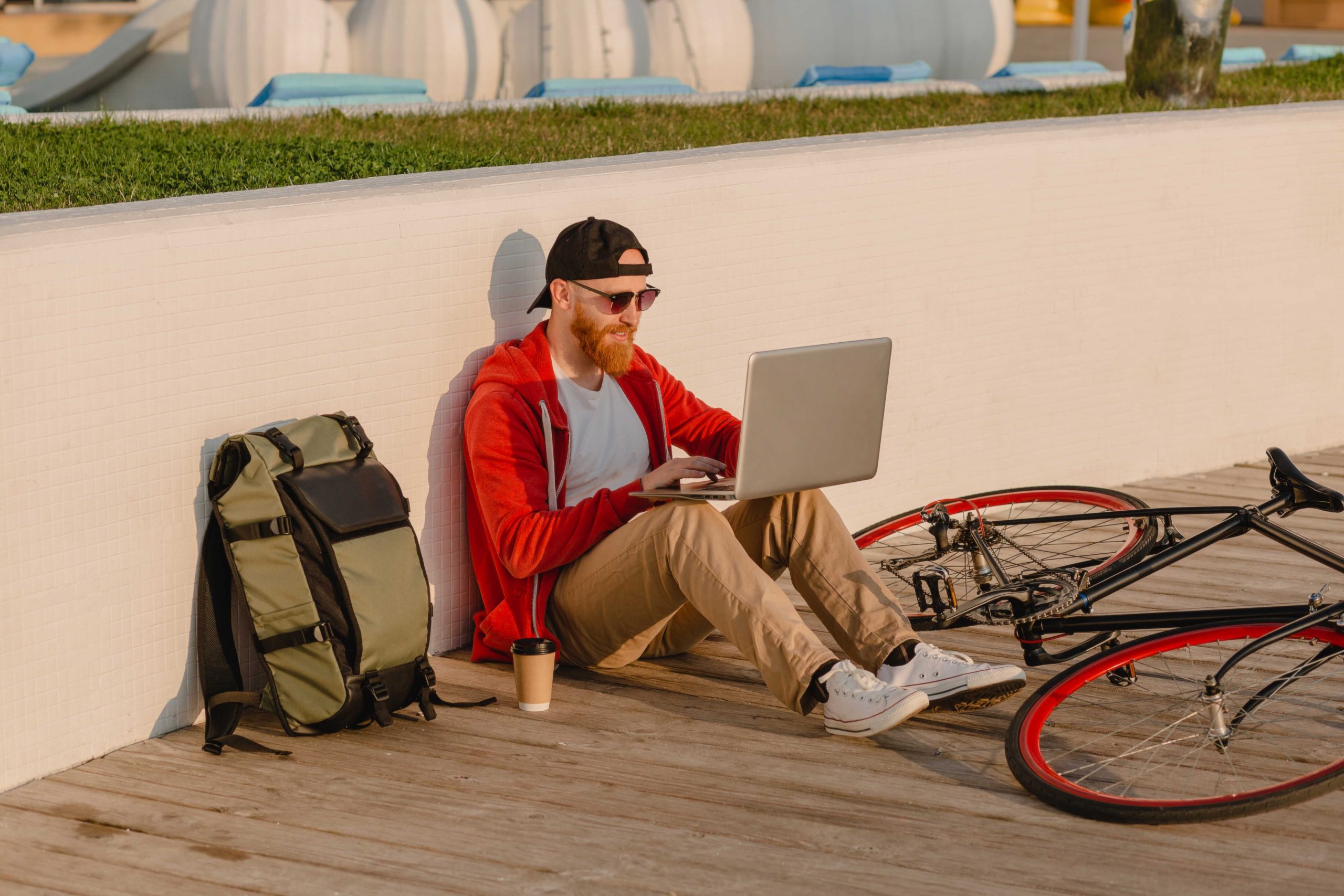 1622542137 Handsome Shipster Style Bearded Man Working Online Freelancer On Laptop With Backpack And Bicycle In Morning Sunrise By The Sea Healthy Active Lifestyle Traveler Backpacker Scaled
