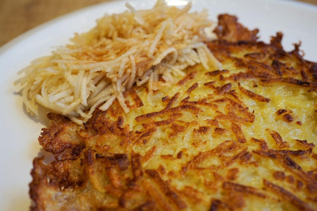 Las tortitas de fritas de patata no solo las puedes comer a la hora de un antojo, sino que también quedan perfectas para acompañar platos con carne de ave, ternera o cerdo acompañadas de una rica salsa. Preparar estas tortitas no tiene nada de complicado y el sabor divino está garantizado; al fin y al cabo, si llevan patatas, nada puede salir mal, puesto que es conocido el rico sabor y versatilidad de este tubérculo. No te pierdas ningún detalle y date el gusto de probarlas. Ingredientes que necesitas para preparar tortitas fritas de patata Para la preparación de las más ricas tortitas fritas de patata, necesitas pocos ingredientes; y de hecho, estos son los más tradicionales, los que son básicos en el menú familiar. Por lo tanto, hacerlas no solo te permitirá disfrutar de un rico plato, sino también, tendrás la oportunidad de preparar de manera diferente esos ingredientes que ya tienes en casa. Los ingredientes que vas a necesitar para prepararlas son: 4 patatas grandes, 2 huevos, 1 cebolla, 2 cucharadas de harina, sal, pimienta, perejil en polvo y aceite de oliva virgen extra. Comienza preparando las patatas Lo primero que debes hacer es preparar las patatas para poder utilizarlas en esta receta, en la que este tubérculo es el protagonista. Lava muy bien las patatas, retírales la piel y pásalas por un rallador. Puedes rallarlas del grosor deseado; aunque por supuesto, el más común es el de grosor medio; puesto que de esta manera, quedarán perfectas para armar las tortitas, pero a la vez se sentirán en cada mordida. Prepara la cebolla La presencia de la cebolla en las preparaciones con patatas, son definitivamente un plus que aporta un rico sabor y mejora considerablemente el resultado del plato, haciéndolo más rico y con un sabor más dulzón. En caso de que no te agrade la idea de añadir cebollas, puedes evitar este ingrediente; sin embargo, te invito a probarlas para que descubras por ti mismo el rico sabor que aportan. En caso de añadirla, pélala y pásala por el rallador para que quede tan pequeña como la patata. Así se prepara la base para estas tortitas fritas de patata Una vez que tengas las patatas y la cebolla perfectamente ralladas, pon ambas en un colador y con la ayuda de tus manos presiona para eliminar el exceso de humedad de ambos ingredientes. Eliminar el exceso de agua es necesario, pues de no hacerlo, será necesario añadir más harina, lo cual hará que no se disfrute bien el sabor de la patata en estas tortitas. Prepara la masa para las tortitas Cuando tengas listas las patatas y la cebolla, ponlas bien escurridas en un bol y añade la harina, huevo, perejil en polvo y sal y pimienta a tu gusto. Mezcla muy bien todos los ingredientes. No es necesario añadir demasiada harina, ya que el huevo y también el propio almidón de las patatas actuará para hacer que las tortitas permanezcan bien compactas al momento de llevarlas a freír. Es por esto que es necesario eliminar el agua excedente antes de mezclar todos los ingredientes. Alista la sartén A la hora de freír, lo más común es utilizar una cantidad generosa de aceite; sin embargo, en este caso, lo mejor será poner solo un poco de aceite. Pon una sartén al fuego medio y vierte un poco de aceite de oliva virgen extra; el cual, como sabes, es el más recomendado para la fritura de, no solo estas tortitas fritas de patata, sino también croquetas, pescados y más. Espera que tome temperatura antes de poner a freír las tortitas. Así se fríen las tortitas Cuando el aceite de oliva virgen extra esté caliente, comienza a darle forma a las tortitas y ponlas a freír. No las hagas demasiado grandes, pues de un tamaño mediano quedan más bonitas a la vista y son más fáciles de comer. Coloca unas dos o tres a freír y espera que tomen color antes de voltearlas. Termina de prepararlas y disfruta Una vez que observes que las tortitas fritas de patata lucen doraditas, dales la vuelta y termina de freírlas para que estén igual de doradas por ambas caras. Cuando las retires de la sartén, llévalas a un plato con papel absorbente para eliminar el exceso de grasa que puedan tener. Termina de hacer las siguientes y sírvelas calientes para que puedas disfrutar de toda su textura crujiente, apenas la tengas listas. Ingredientes que puedes utilizar para darles más sabor A estas ricas tortitas fritas de patata, la cebolla y el perejil le dan un sabor exquisito; ahora bien, puedes añadir otros ingredientes para aromatizarlas y lograr un plato realmente único que combine con lo que desees acompañarlas. Puedes añadir un poco de ajo en polvo o un poco de ajo natural finamente picado. También, si te gusta el picante, eres libre de añadir un toque de guindilla para que queden picositas. Con relación a las hierbas que puedes incorporar, el orégano, romero o cebollino, les darán mucho sabor. Cómo lograr tortitas fritas de patata perfectas Para lograr que las tortitas fritas de patata queden bien compactas, lo mejor es utilizar unas buenas patatas que tengan una cantidad de almidón adecuada. Si usas patatas nuevas, estas tendrán menor cantidad de este elemento que actúa como aglutinante y reduce la cantidad de harina a añadir. Al momento de freírlas, recuerda ponerlas en pequeñas cantidades para evitar las drásticas fluctuaciones de temperatura en el aceite. También, recuerda hacerlas de un tamaño más bien pequeño o mediano para que resulten perfectas para comer. Si disfrutas las recetas originales con patatas, conoce esta receta viral que te hará comerlas con frenesí. Y además, aprovecha también esta receta para prepararlas al ajillo y ten lista la guarnición perfecta para carnes en unos minutos.