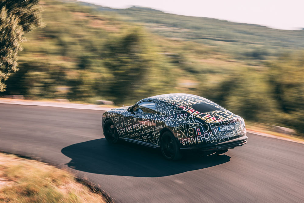 Camouflaged Rolls-Royce Spectre. Rear moving image.