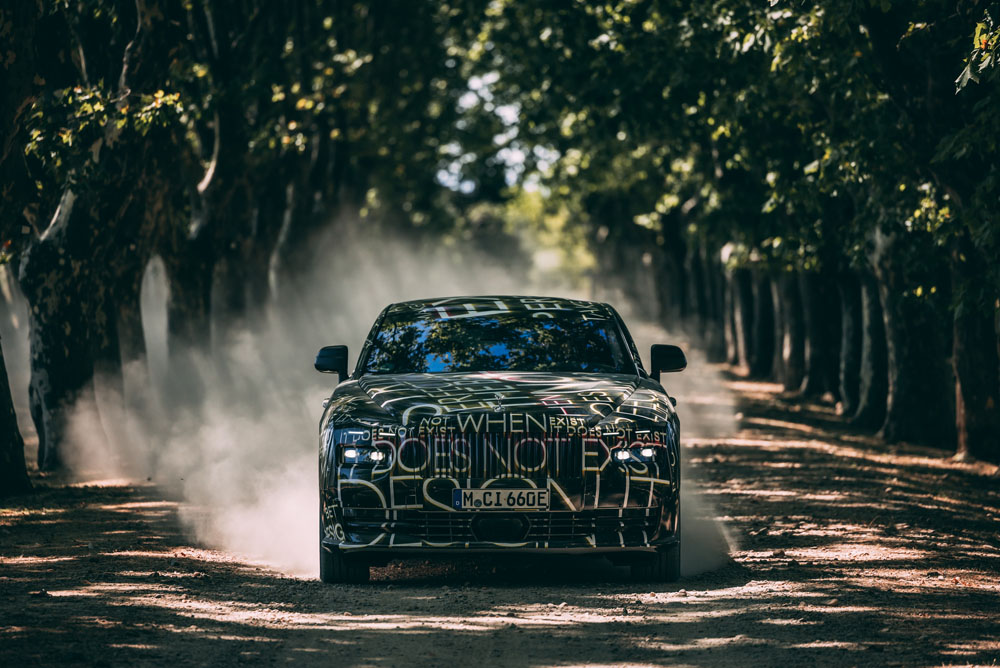Camouflaged Rolls-Royce Spectre.  Forward moving image.