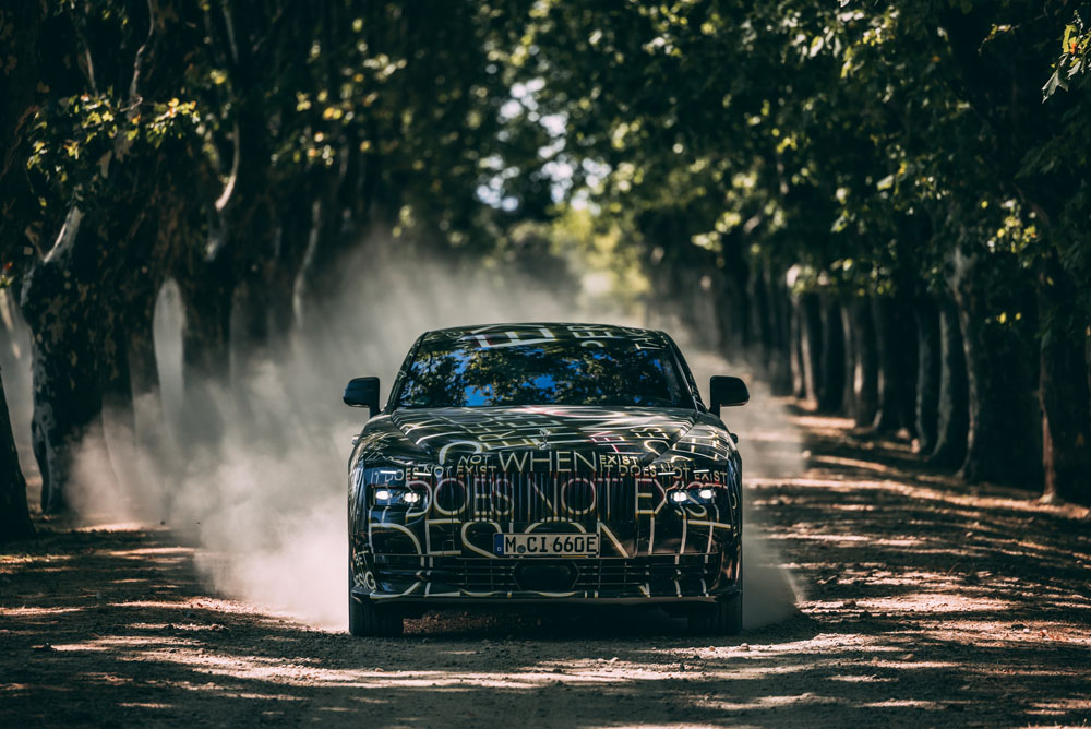 Camouflaged Rolls-Royce Spectre. Forward moving image.