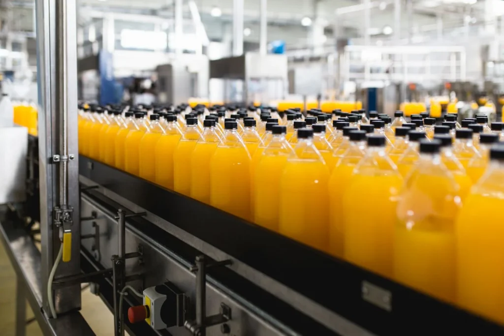Bottling Factory Orange Juice Bottling Line Processing Bottling Juice Into Bottles Selective Focus