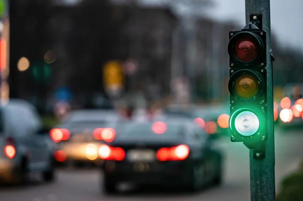 un cruce de la ciudad con un semaforo en el fondo borroso con coches en las calles de la noche luz verde Moncloa