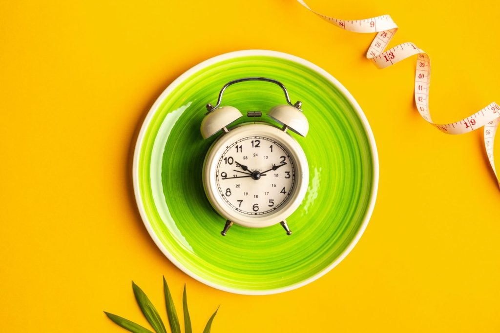 composicion con placa despertador y cinta metrica sobre un fondo de color concepto de dieta y plan de perdida de peso espacio de copia