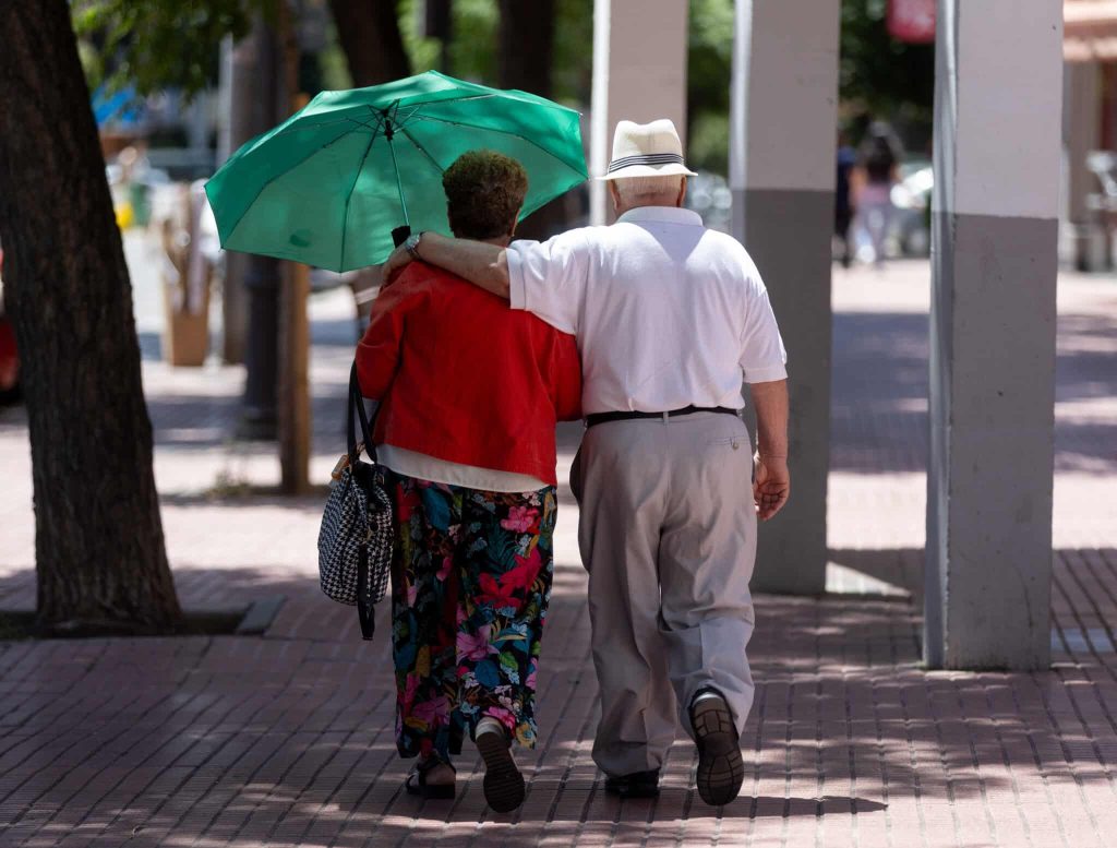 Bebés, Mayores, Animales Y Personas Con Movilidad Reducida, Las Víctimas Silenciosas Del Calor Del Verano 1 Dos Personas Mayores Caminan Bajo La Sombra De Un Árbol