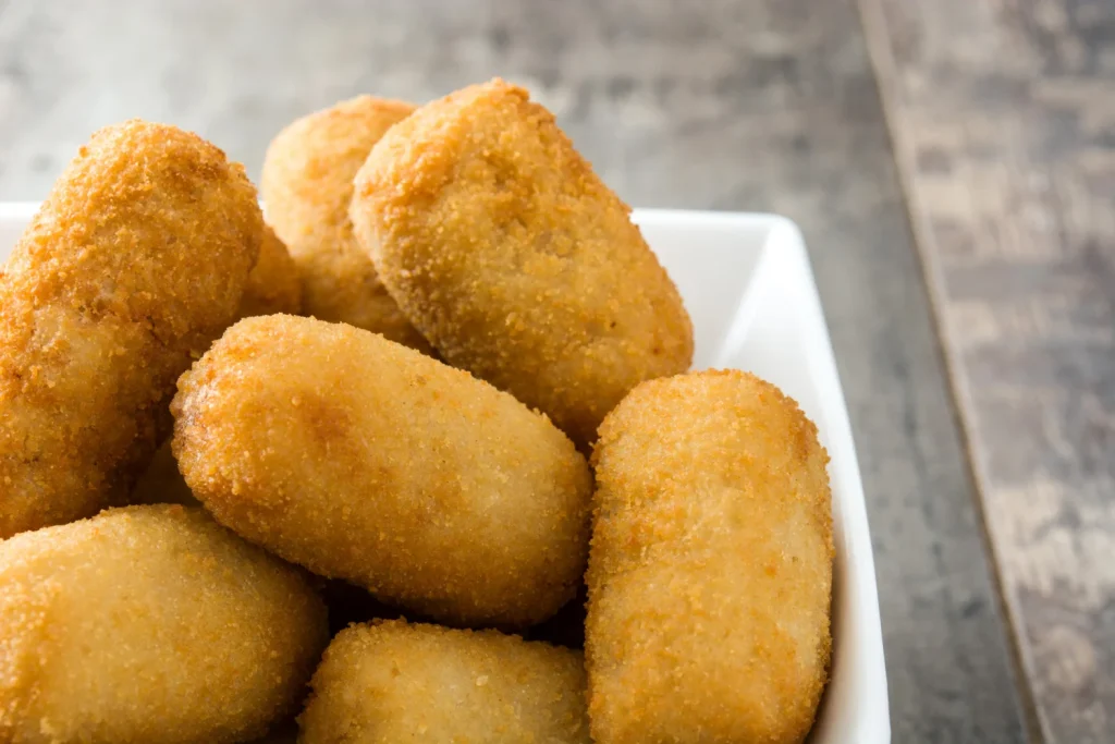 Si Tus Croquetas Se Rompen, No Es La Bechamel: El Error Garrafal Que Cometes 30 Segundos Antes De Meterlas En El Aceite. 3 Una Vez Dominada La Temperatura, Hay Un Último Detalle Para Unas Croquetas Memorables. Fuente: Freepik
